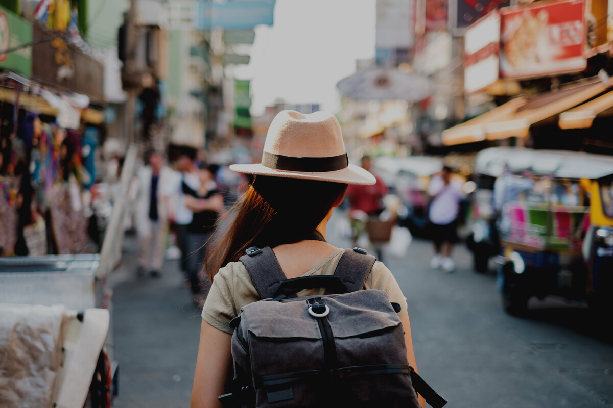 Back view Asian woman tourist backpacker travel in Khao San road, Bangkok, Thailand